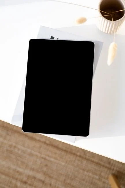 Gros plan d’un smartphone affichant une interface d’application de facturation posé sur une surface réfléchissante.